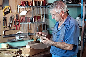 Work cabinetmaker looking handcrafted wooden pieces in garage at