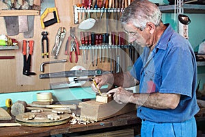 Work cabinetmaker marking handcrafted wooden pieces in garage at