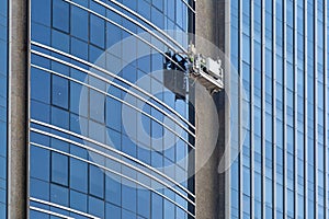 A worker washes the glass of a multi-storey building. photo