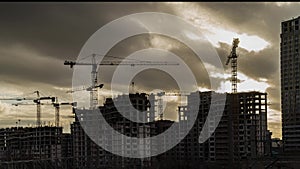 The work of construction cranes on the background of clouds,time lapse