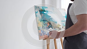 Work on creating an abstract painting in the studio in white.
