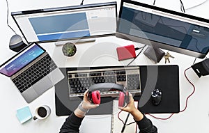 Work desk with multiple screens and electronic devices.