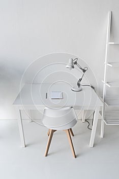 stylish white workplace with table lamp