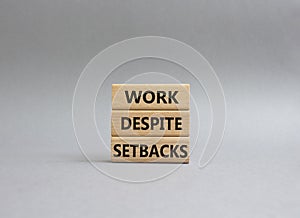 Work despite setbacks symbol. Wooden blocks with words Work despite setbacks. Beautiful grey background. Business and Work despite