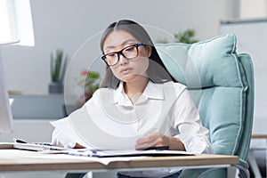 Work with documents. Portrait of a young business woman Asian accountant works