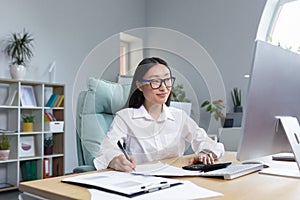 Work with documents. Portrait of a young business woman Asian accountant works with documents