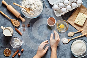 Work with the dough. The kitchen table raw ingredients, the woman`s hand ready to knead the preparing ginger cake