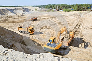 Work of the excavator and truck at a sand quarry