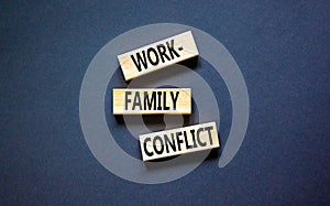 Work-family conflict symbol. Concept words Work-family conflict on wooden block on a beautiful black table black background.