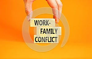 Work-family conflict symbol. Concept words Work-family conflict on wooden block on a beautiful orange table orange background.