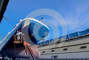 Work in floating dry dock with water jet cleans the shipboard.