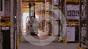 Work forklifts in the warehouse. Forklift with boxes rides between the rows in the warehouse. Industrial interior