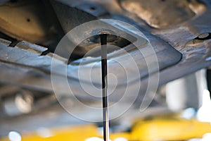 work in a garage , worker controls and changes the motoroil