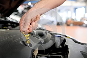 Work in a garage - worker controls and changes the motoroil