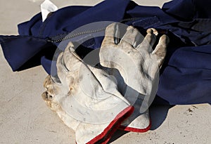 Work gloves over a worker overalls during the strike of workers