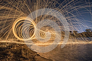 work of glowing sparks from spinning steel wool by human.