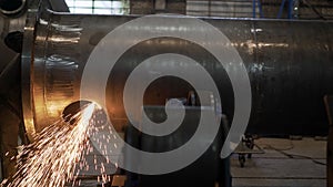 Work grinder cuts metal at the factory. Heavy industry worker cuts a huge pipe