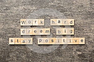 Work hard dream big stay positive word written on wood block. Work hard dream big stay positive text on cement table for
