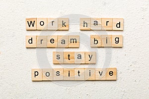 Work hard dream big stay positive word written on wood block. Work hard dream big stay positive text on cement table for