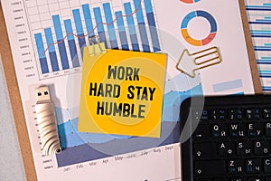 WORK HARD STAY HUMBLE text concept write on a notebook