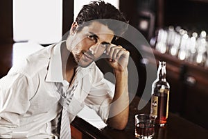 Work hard to wind down - Fast-paced Professional. A handsome young man winding down after work with a drink at the bar.
