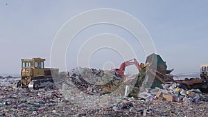 Work of heavy machinery in garbage dump in winter, Russia