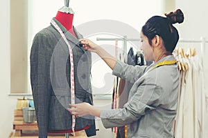 Work from home. Asian young woman fashion designer  working on her design in the showroom.