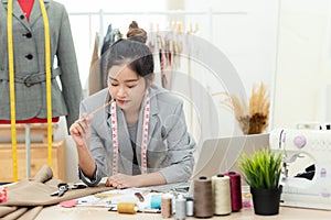 Work from home. Asian young woman fashion designer  working on her design in the showroom.