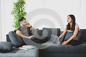 Work at home concept, Working from home, Couple using laptop working together in their living room. Corona virus, Covid-19, Stay