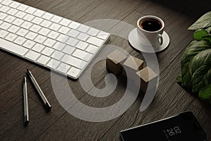 Work from home. desk office with keyboard, blank wooden cubes, coffee cup and pen on wood table. Flat top view