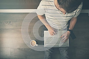 Work from home - man sitting on the floor and using laptop computer