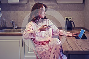 Work from home during quarantine and isolation due to the corona virus epidemic. Woman calls on the phone sitting in her pajamas