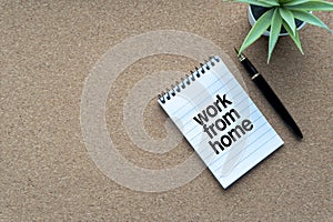 WORK FROM HOME text with notepad, decorative plant and fountain pen on wooden background