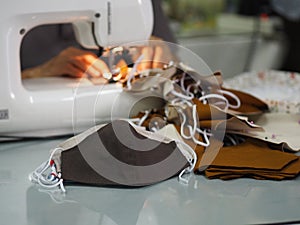 Work at home woman sitting sewing a fabric mask, for dust and germs pm 2.5, virus covid 19
