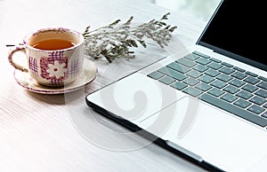 Work from home, workspace office at home, Notebook or laptop computer with Chinese tea cup  on the white desk at home office