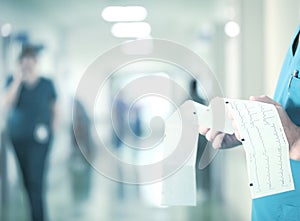 Work at the hospital. Doctor examines the ECG on the background