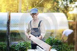 Work on the infield. Do it yourself. A carpenter processes wooden boards on the street using an electric woodworking