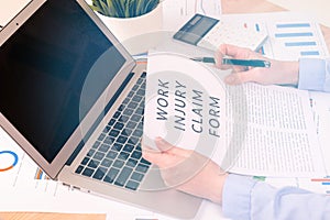 Work injury claim form concept, documents on the desktop