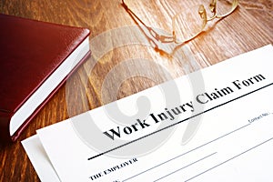 Work injury claim form and glasses on desk