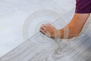 Work on laying worker installing new vinyl tile laminate floor