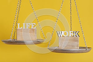 Work and life balance concept. Balance scales on yellow background, close up