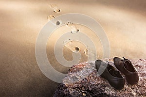 Work Life Balance Concept, Businessman take off his Working Oxford Shoes and leave it on the Beach Rock for Walk into the Sea in