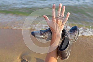 Work Life Balance Concept, Businessman take off his Working Shoes and holds the laces in his hand. Close-up