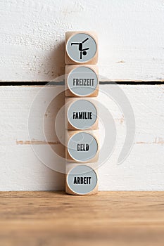 Work-life balance concept with the German words for FREETIME, FAMILY, MONEY, WORKon wooden cubes