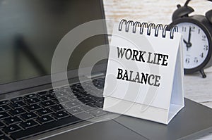 Work life balance text on table notepad with laptop background. Working culture concept