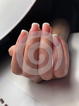 The work of a manicure master. Hands of a beautiful young woman and modern design