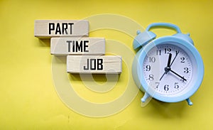 WORK PART OF THE TIME - words on wooden blocks and on a yellow background with an alarm clock. Business concept