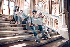 Work with the people that motivate and inspire you.Group of students studying while sitting on stairs in university