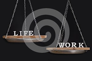 Work and personal life balance concept. Seesaw. Scales on black background close up