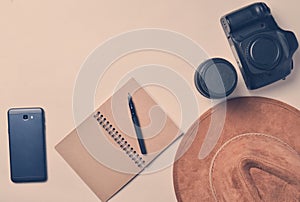 Work of the photojournalist. Smartphone, notebook, hat, camera,